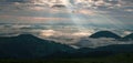 Amazing sunrise in the mountains. Great view of the foggy valley with bright sun rays in Carpathians.