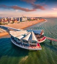 Amazing sunrise on public beach of Lignano Sabbiadoro town with modern building on the shore. Royalty Free Stock Photo