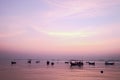 Fishing boat silhouette with orange sunrise sky and water reflection