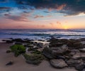 Amazing sunset on the ocean. View of dramatic cloudy sky and stony coast. Portugal.