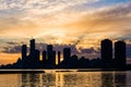 Amazing sunset over sityscape. Cloudy sky with sun rays, water reflection. City modern buildings Royalty Free Stock Photo