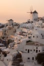 Amazing Sunset over white windmills in town of Oia and panorama to Santorini island, Thira, Greece Royalty Free Stock Photo