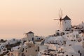 Amazing Sunset over white windmills in town of Oia and panorama to Santorini island, Thira, Greece Royalty Free Stock Photo