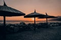 Amazing sunset seascape. Straw beach umbrella and light orange sky. Brela Croatia, Makarska riviera Royalty Free Stock Photo