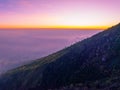 Amazing Sunset or sunrise landscape with high peaks and foggy forest under vibrant colorful sky clouds over mountains Royalty Free Stock Photo