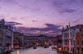 Amazing sunset in Venice over Grand canal with typical Venetian buildings, lighting lights and boats. Royalty Free Stock Photo