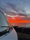Amazing sunset viewed from outiside a camper van parking on the coast. Freedom and journey alternative vanlife lifestyle. Renting Royalty Free Stock Photo