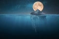 Amazing tip of the iceberg floats in the ocean at night with stars and full moon. Hidden danger underwater. Global warming,