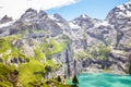 Amazing top view of Oeschinensee lake by Kandersteg, Switzerland. Turquoise lake surrounded by steep mountains and rocks. Swiss Royalty Free Stock Photo