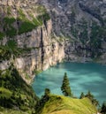 Amazing tourquise Oeschinnensee with waterfalls, wooden chalet and Swiss Alps, Berner Oberland, Switzerland. Royalty Free Stock Photo