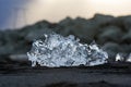 Amazing transparent blue iceberg pieces on Diamond beach with black sand near Jokulsarlon lagoon, Iceland. Ice calving. Black and