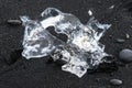 Amazing transparent blue iceberg pieces on Diamond beach with black sand near Jokulsarlon lagoon, Iceland. Ice calving. Black and