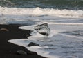 Amazing transparent blue iceberg pieces on Diamond beach with black sand near Jokulsarlon lagoon, Iceland. Ice calving. Black and