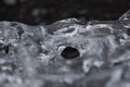 Amazing transparent blue iceberg pieces on Diamond beach with black sand near Jokulsarlon lagoon, Iceland. Ice calving. Black and