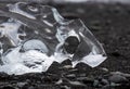 Amazing transparent blue iceberg pieces on Diamond beach with black sand near Jokulsarlon lagoon, Iceland. Ice calving. Black and