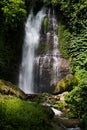 Amazing tropical cascade waterfall in wild green forest with powerful stream of water in sunbeams with water splashes and lush. Royalty Free Stock Photo