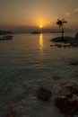 Amazing tropical sunrise over a coconut tree island and the sea horizon Royalty Free Stock Photo