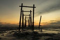 Amazing tropical sunset background, wooden structure on the muddy beach Royalty Free Stock Photo