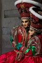 Amazing twins couple with big hat and venetian mask during venice carnival Royalty Free Stock Photo