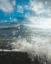 Amazing vertical shot of sea waves crashing under the beautiful cloudy sky Royalty Free Stock Photo