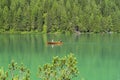 Amazing view of the famous Braies Lake in Italy. People row the traditional boats made of wood. Alpine lake. Picturesque mountain