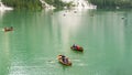 Amazing view of the famous Braies Lake in Italy. People row the traditional boats made of wood. Alpine lake. Picturesque mountain