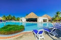 Amazing view of hotel grounds with nice inviting swimming pool and people relaxing in water in tropical garden