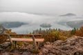 Amazing view of Lake Bled at foggy autumn morning wiyh wooden bench on foreground Royalty Free Stock Photo