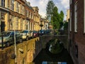 An amazing view of the old canal with bridges and a cozy street with beautiful houses, cars and bicycles. Utrecht, Netherlands Royalty Free Stock Photo