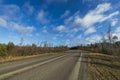 Amazing view over spring forest with green trees on blue sky with white clouds background. Green yellow trees and road. Royalty Free Stock Photo