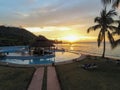 A pool at a resort in Ilheu das Rolas, Sao tome with sunset reflecting in the sea