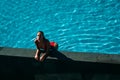 Amazing view of girl relaxing at swimming pool. Pretty young woman in red bikini posing. Concept of swimsuit Royalty Free Stock Photo