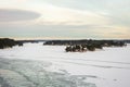 Amazing view of snowy coast of the frozen Baltic sea in winter. Forestry islands with little wooden houses. Royalty Free Stock Photo