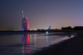 Amazing view to the illuminated Burj al Arab, luxury and modern hotel in Dubai. Colorful lights reflects over the water. Royalty Free Stock Photo