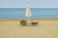 Amazing view of two empty sun beds and sun umbrella on beach near water. Royalty Free Stock Photo