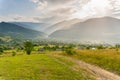 Amazing view on valley with village between mountains under summer rain Royalty Free Stock Photo