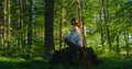 Amazing view woman meditate sitting ion a stump in dense forest. Breathing exercises to restore the respiratory system Royalty Free Stock Photo