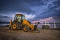 Yellow excavator with a shovel at a construction site in a beautiful twilight Royalty Free Stock Photo