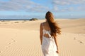 Amazing view of young woman walking barefoot on desert dunes at sunset in Corralejo, Fuerteventura Royalty Free Stock Photo