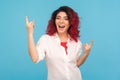 Amazing vivid hipster woman with fancy red hair in white shirt feeling happy crazy, showing rock n roll sign