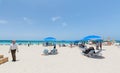 amazing white sand beach, turquoise ocean on blue sky with people relaxing, swimming,walking and enjoying their time on sunny