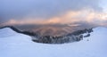 Amazing winter dramatic sky. Fantastic sunrise. Panoramic view of the covered with frost trees in the snowdrifts, mountain.