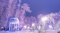 Amazing winter landscape in evening park. Gazebo, lantern lights, snow and frosty trees. Artistic picture. Beauty world