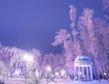 Amazing winter landscape in evening park. Gazebo, lantern lights