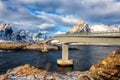 Amazing winter landscape, Lofoten Islands, Norway. Scenic view of the snowy rocky mountains, bridge, water and blue sky with cloud Royalty Free Stock Photo