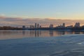Amazing winter landscape during sunset. Frozen part of the Dnieper River. Buildings reflected in the tranquil water