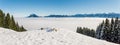 Amazing winter panoramic view to snowy Mountain Range above inversion fog clouds with forest trees. Sunny view from Royalty Free Stock Photo