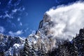 Amazing winter weather, blue sky and clouds coming of the rocks Royalty Free Stock Photo