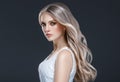 Amazing woman portrait. Beautiful girl with long wavy hair. Blonde model with hairstyle over black background Royalty Free Stock Photo