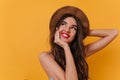 Amazing young white woman with inspired smile looking up. Indoor photo of lovely brunette girl in brown hat chilling on Royalty Free Stock Photo